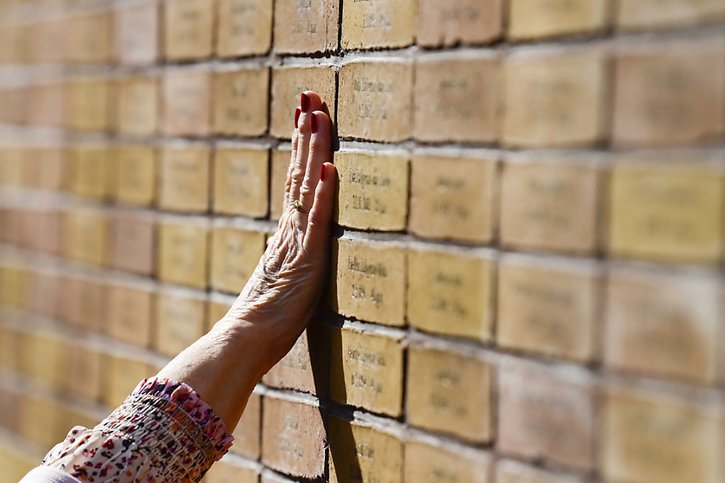 Sur chacune des briques formant le mémorial est inscrit un nom, une date de naissance et un âge de décès. © KEYSTONE/EPA/Olaf Kraak