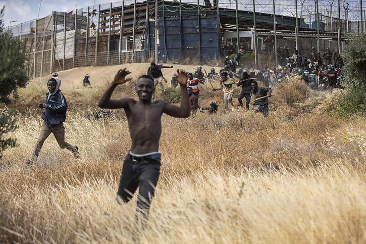 Migrants courant sur le sol espagnol après avoir traversé la frontière entre le territoire marocain et l'enclave espagnole de Melilla. © KEYSTONE/AP/Javier Bernardo
