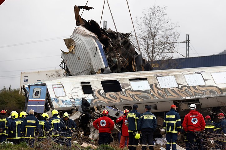 Les secouristes utilisaient deux grues géantes pour transporter des morceaux des carcasses des trains. © KEYSTONE/EPA/ACHILLEAS CHIRAS