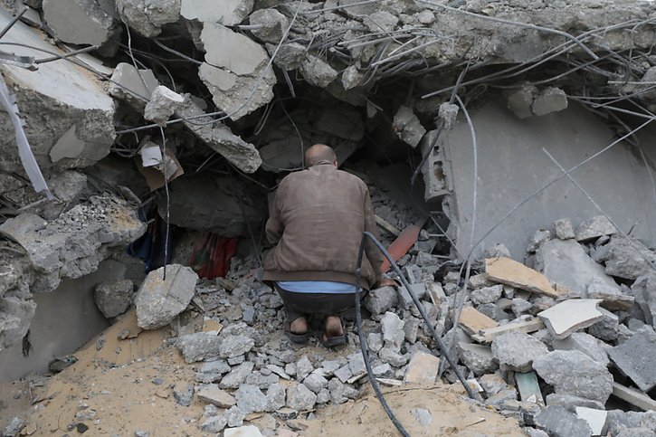 Selon le ministère de la Santé du Hamas, le bilan des victimes dépasse 17'700 morts dans la bande de Gaza, pour la plupart des femmes et des enfants. Ici, un homme à la recherche de blessés dans les décombres d'une maison à Deir Al Balah, au centre de la bande de Gaza. © KEYSTONE/EPA/MOHAMMED SABER
