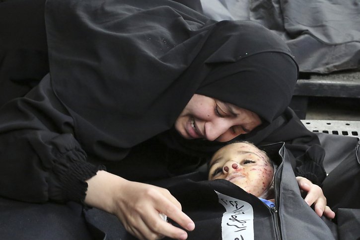 Une femme près d'un enfant tué dans un bombardement israélien à la morgue de Khan Younès. © KEYSTONE/AP/Hatem Ali