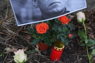 Sous surveillance, des personnes fleurissent la tombe de Navalny